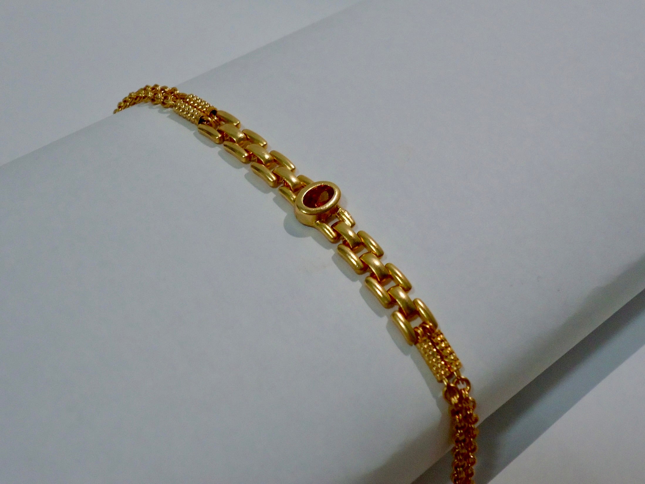 Gold bracelet on a white surface
