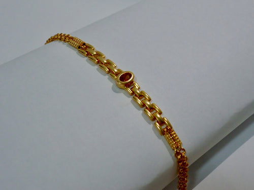 Gold bracelet on a white surface